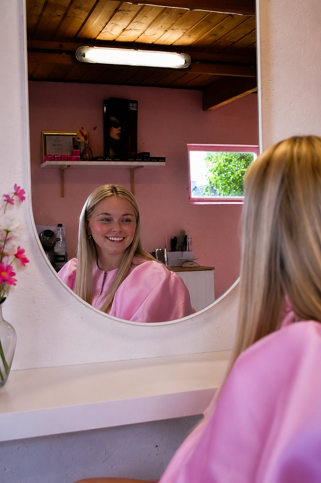 Axelle aan de spiegel in haar kapsalon GLOSSELLE in Rumbeke bij Roeselare