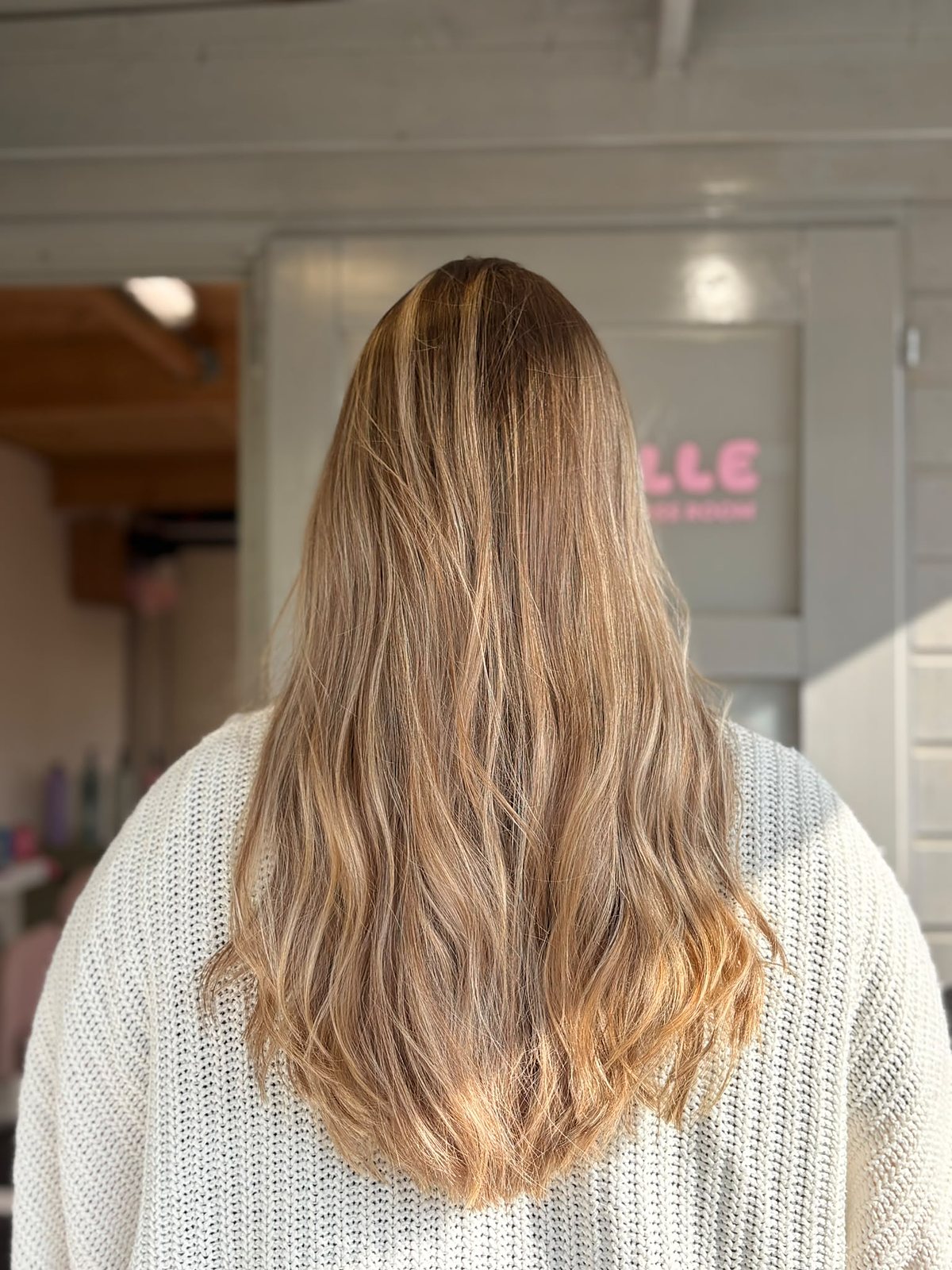 Achteraanzicht na de behandeling: goudblond met highlights en zachte beweging